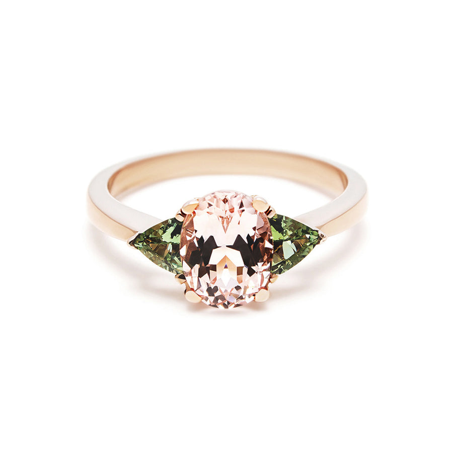 The Tavi engagement ring looks beautiful on the finger with it's tapered band and oval morganite. Locally cut green sapphires give the illusion of leaves on a flower. This is a feminine and elegant ring for a bride looking for an diamond alternative. 