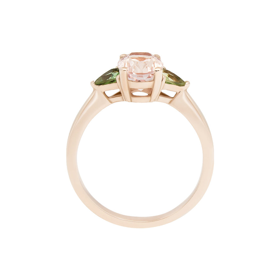 This is a side view of the Tavi ring, which features an oval morganite and hand-cut green sapphires. The ring is made in a 14 karat rose gold setting which adds warmth and compliments the pink morganite. 