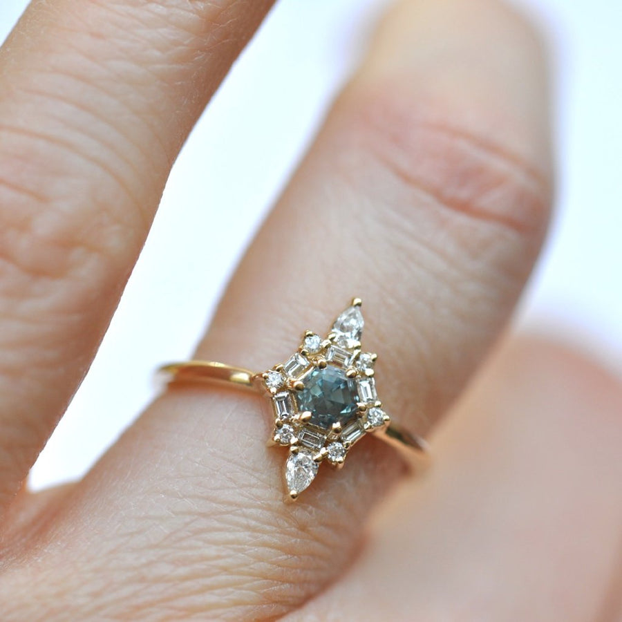 Hexagon shaped Montana sapphire in a diamond halo on a hand