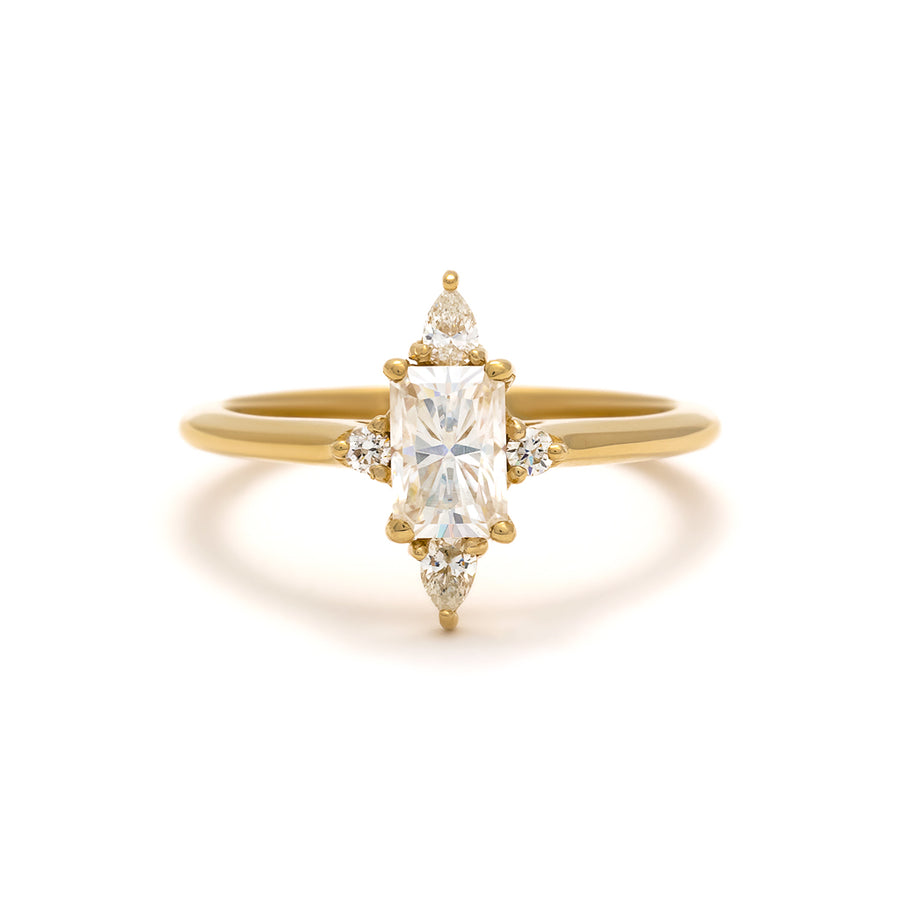 The Felicity Ring features a half carat emerald cut diamond with pear and round accent stones. 